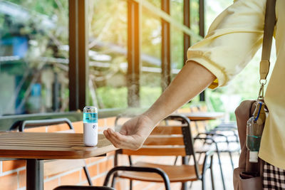 Cropped image of woman holding coffee cup on table in cafe