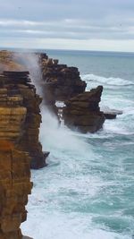 Rock formations by sea against sky