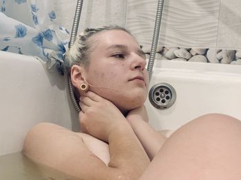 Young woman relaxing in bathtub at home