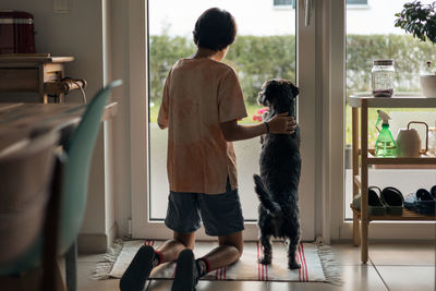 Side view of woman with dog standing in gym