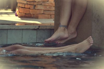 Low section of woman standing on wooden floor