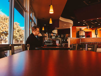 Side view of man sitting in restaurant