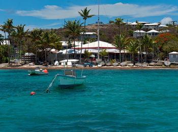 Boats in swimming pool by sea against sky