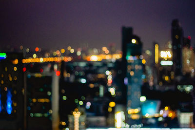 Defocused image of illuminated city buildings at night