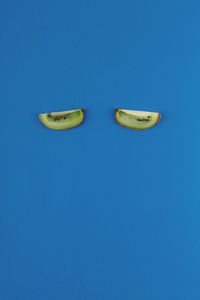 Kiwi slices like eyes on a blue background. food concept for sleep and insomnia treatment