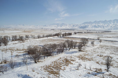Scenic view of snow covered land against sky