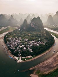 Aerial view of townscape and mountains against sky