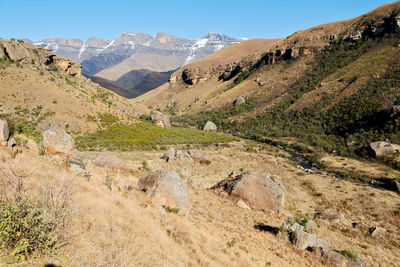 Scenic view of landscape and mountains against clear sky