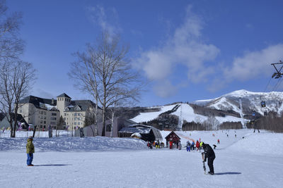 People on snowcapped mountain against sky