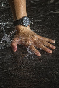 Low section of woman standing on wet surface