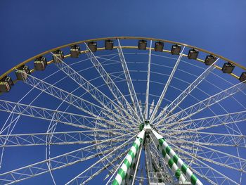 Low angle view of ferris wheel against blue sky