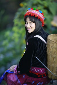 Portrait of smiling woman sitting outdoors