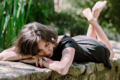 Portrait of woman lying on rock