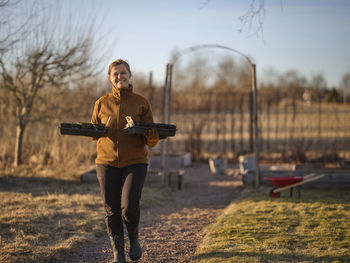 Woman carrying seedlings in garden