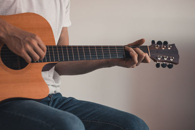 Midsection of man playing guitar