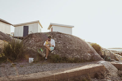 Man standing on rock against clear sky