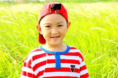Portrait of smiling boy standing on field
