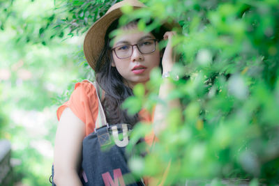 Portrait of woman standing by plants