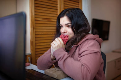 Portrait of young woman drinking coffee at home