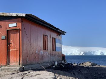 House by sea against clear blue sky