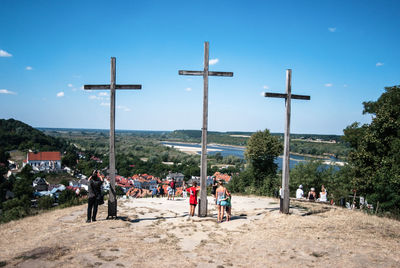 People standing by crosses against blue sky at wlodawa