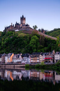 Reichsburg cochem at waterfront against sky