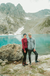 Full length of man standing on rock by lake