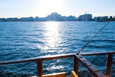 Sea by cityscape against sky