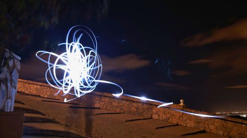 Close-up of illuminated lighting against sky at night
