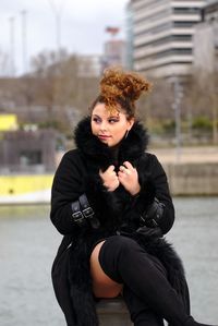 Portrait of young woman in city during winter