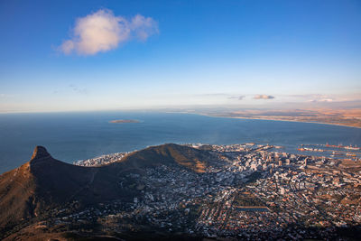 Aerial view of city by sea against sky