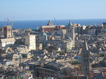 High angle view of cityscape by sea against clear sky