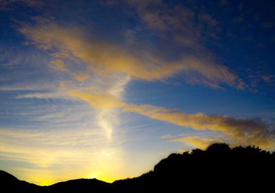 Low angle view of silhouette mountain against dramatic sky