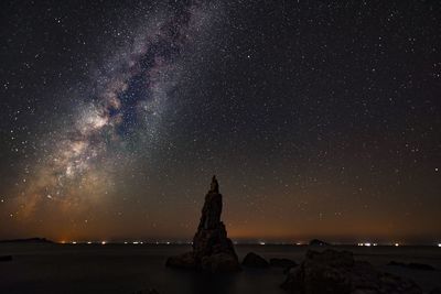 Scenic view of sea against star field at night