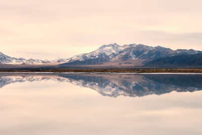 Scenic view of lake and mountains against sky during sunset