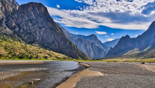 Scenic view of road by mountains against sky