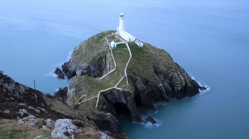 High angle view of lighthouse on rock at sea shore