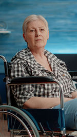 Portrait of woman sitting on wheelchair