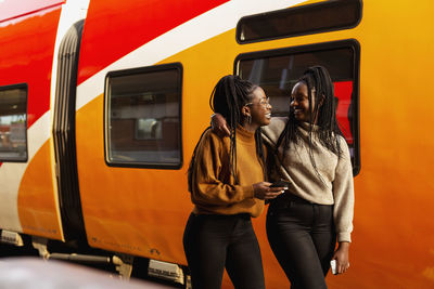 Female friends walking at train station