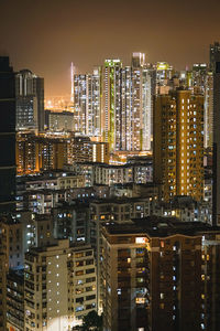 Illuminated buildings in city against sky at night