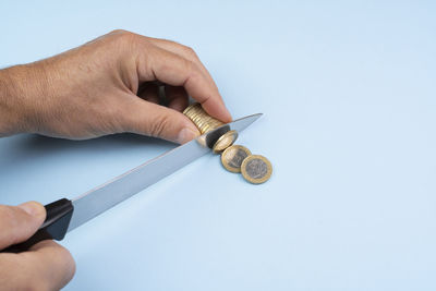 The gesture of cutting one euro coins with the knife. concept of installment payment of debt.