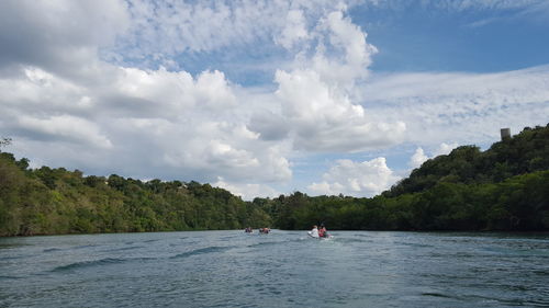 Panoramic view of people on sea against sky