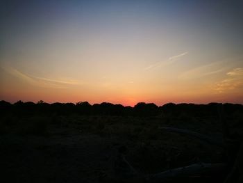 Scenic view of silhouette field against sky during sunset