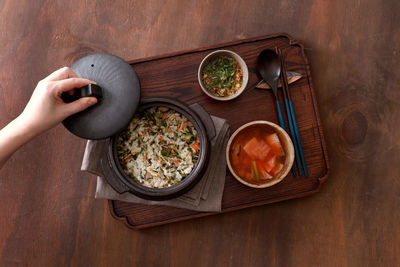 Directly above shot of hand holding food on table