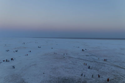 Group of people on beach against sky