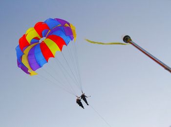 Low angle view of person paragliding against clear sky