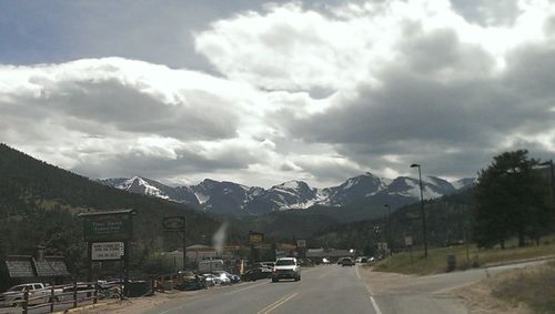 Cars on road by mountain against sky