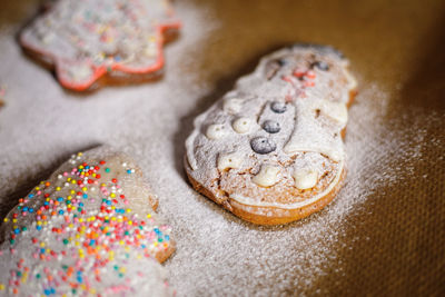 Christmas cookies sprinkled with icing sugar on a baking sheet.
