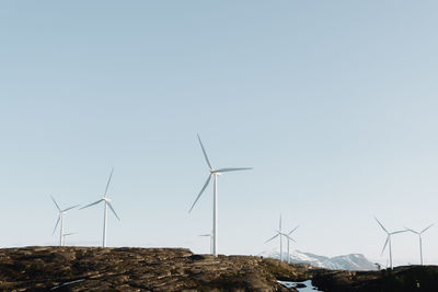 Low angle view of windmills against clear sky