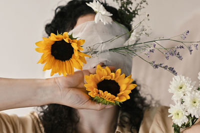 Cropped hand of woman holding yellow flower